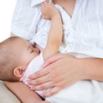 Mom breastfeeding baby in white shirt