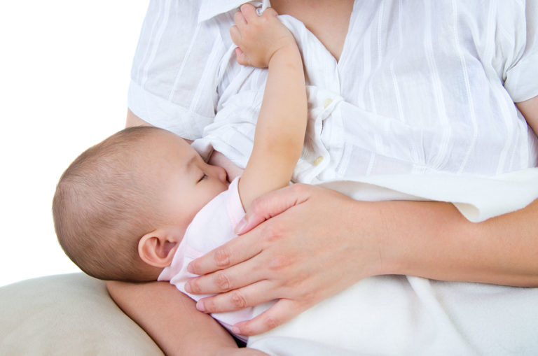 Mom breastfeeding baby in white shirt