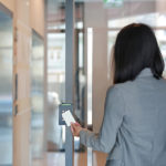 Young business woman holding keycard to get into