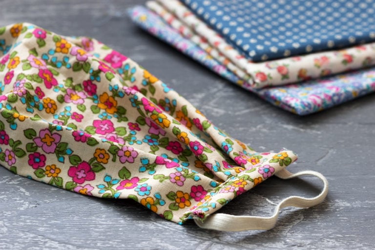 Decorative homemade surgical mask and different patterned cloths behind