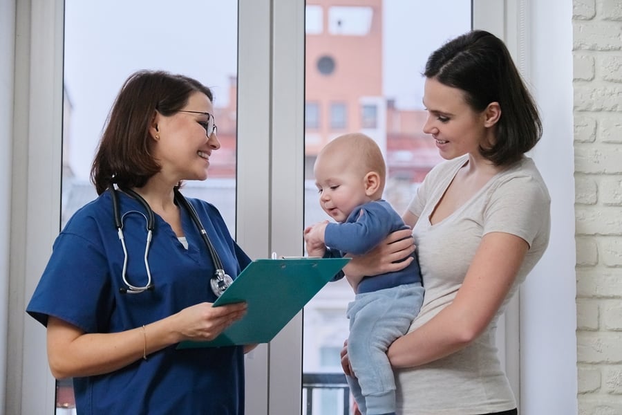 Nurse speaking with mother holding infant