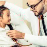 Male PNP listening to stethoscope of little girl