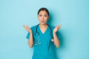 Nurses holding up hands in confused posture.