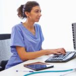 Female nurse studying at computer.