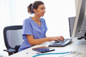 Female nurse studying at computer.