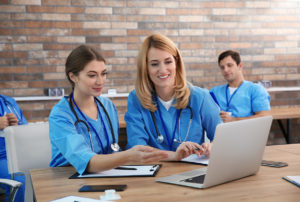Nursing students enrolled in BSN to DNP program learning on laptops